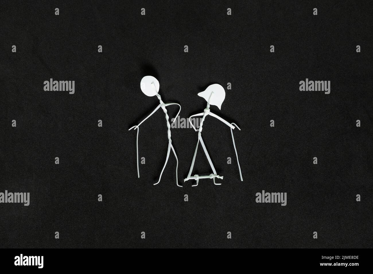 Les grands-parents de jour et les aînés ou les personnes âgées questions sociales, les droits et le concept de bien-être. Un couple de personnes âgées se tient sur fond noir foncé. Banque D'Images