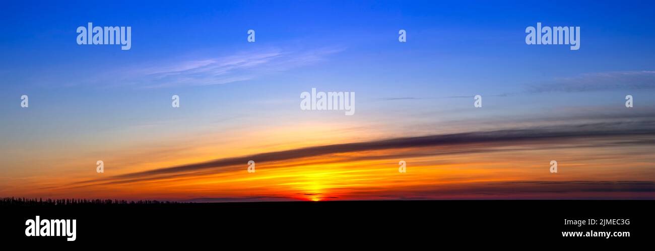 Ciel bleu vif et orange le matin. Lever du soleil à l'horizon. Estomper les nuages et l'arrière-plan. Banque D'Images