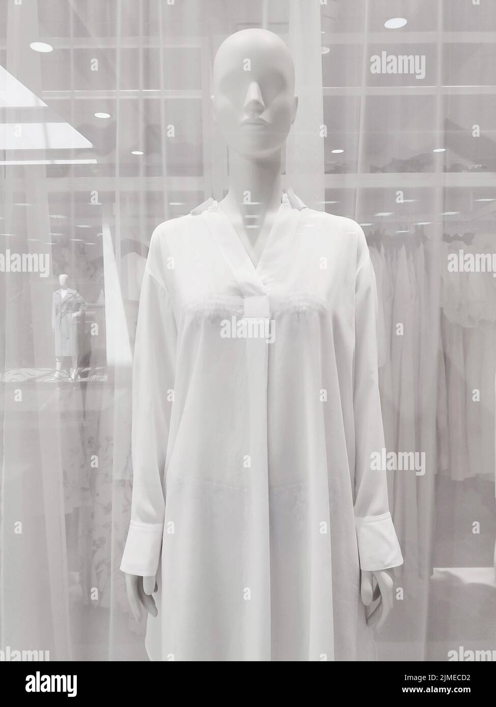 Vitrine du magasin de vêtements, mannequin en chemise blanche Banque D'Images