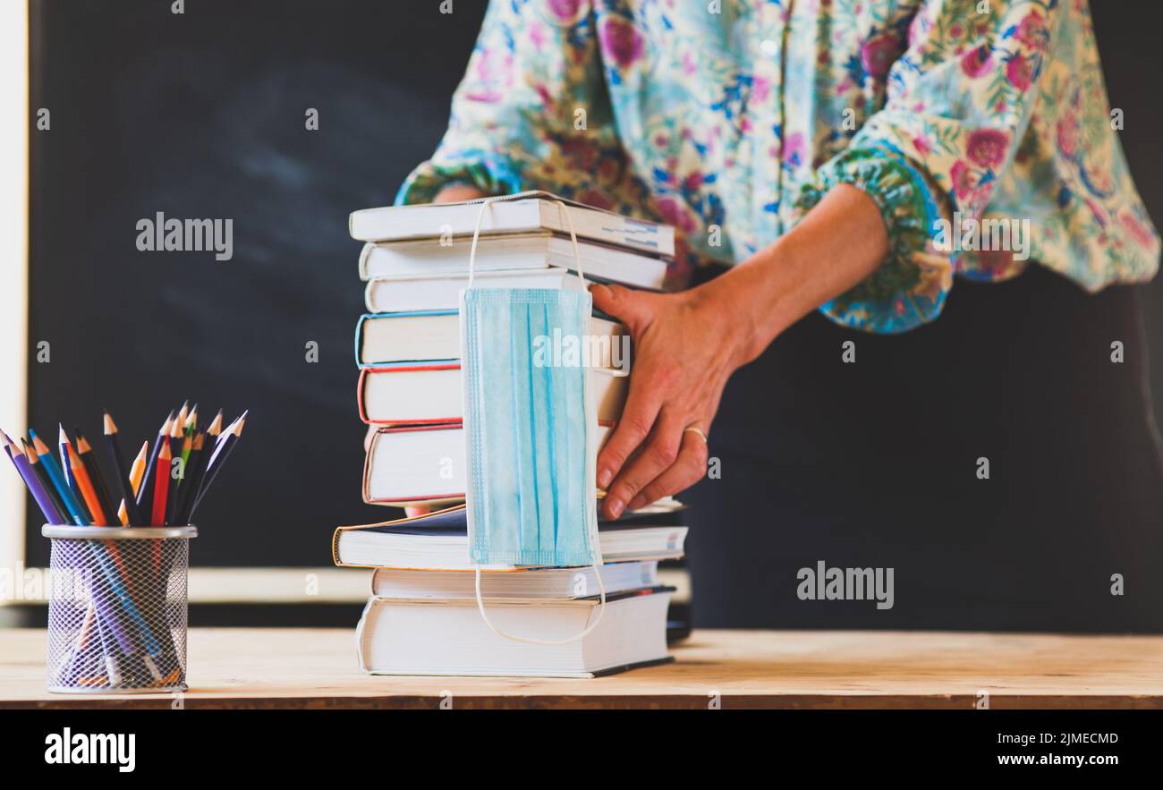 Retour à l'école concept pendant le covid - pile de livres et masque médical Banque D'Images