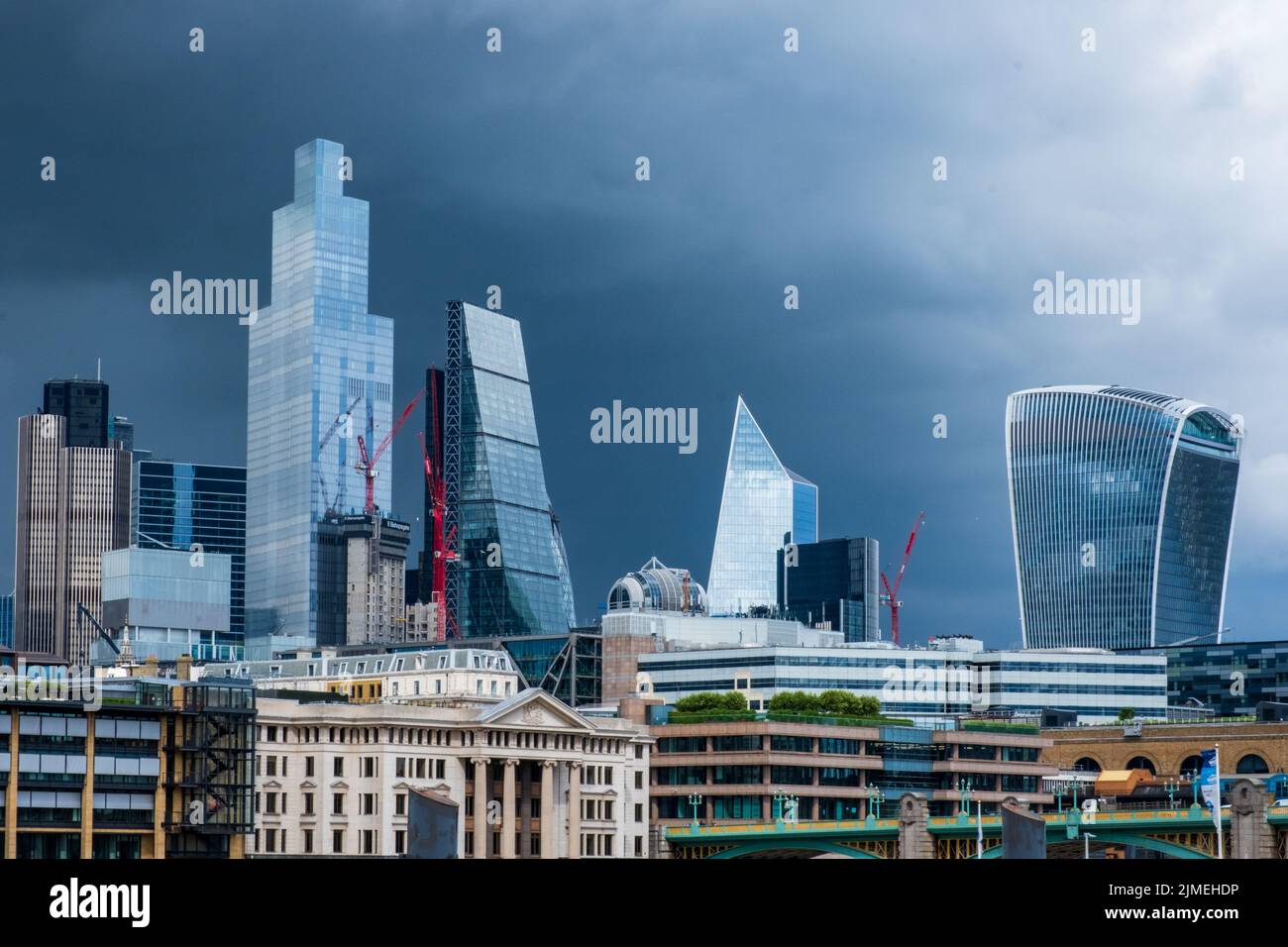 Quartier des affaires de la ville de Londres, gratte-ciels éclatants, dans un ciel de tempête spectaculaire. Banque D'Images