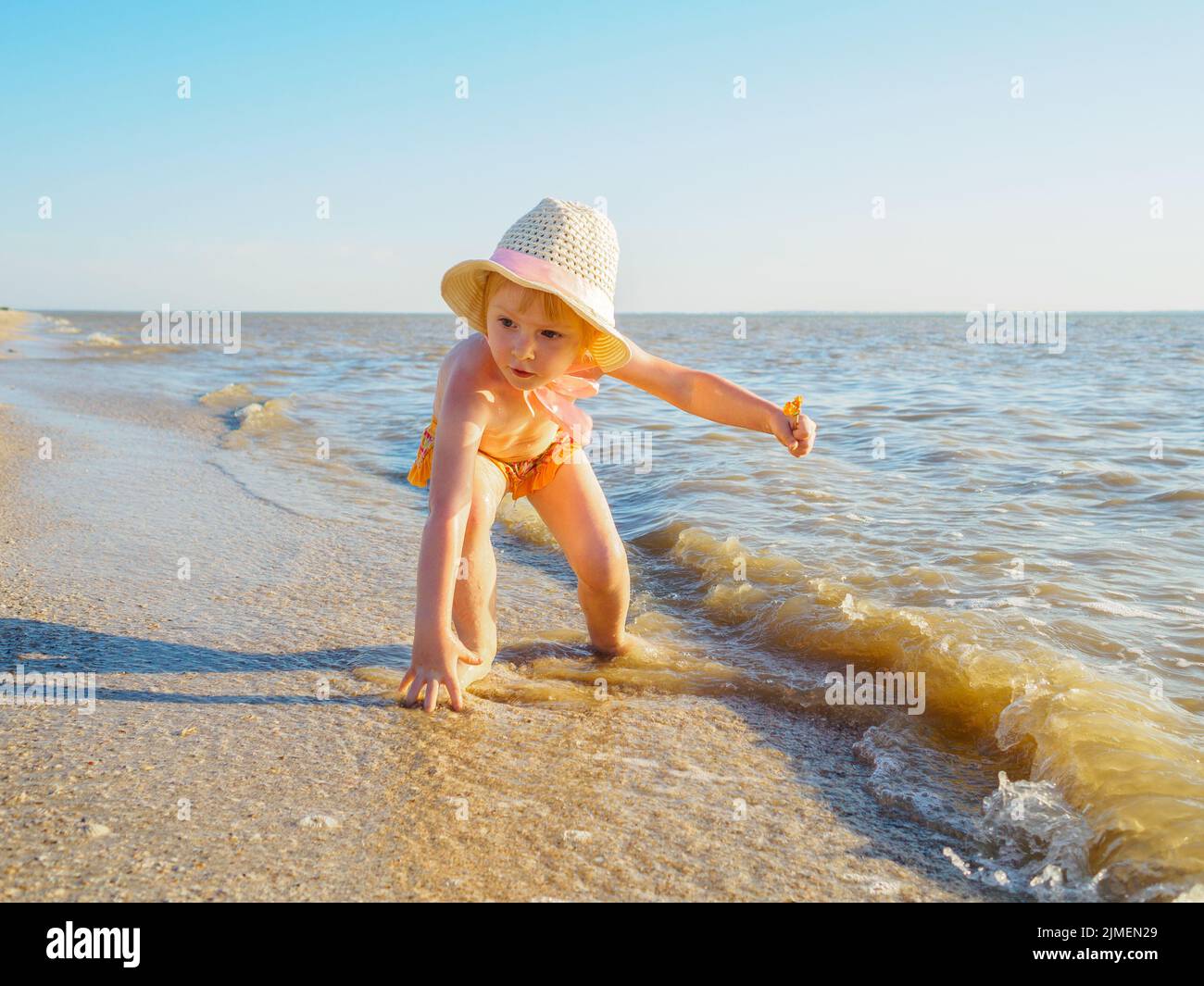 Enfant fille dans un chapeau panama et des culottes pour la natation bathes dans la mer Banque D'Images