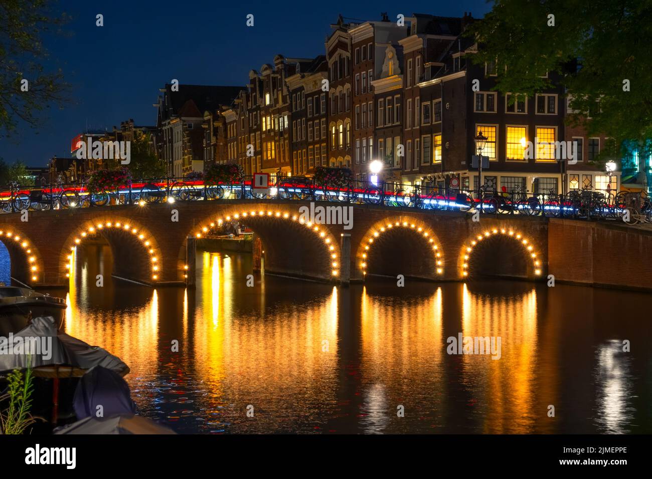 Canal d'Amsterdam la nuit et pont illuminé Banque D'Images