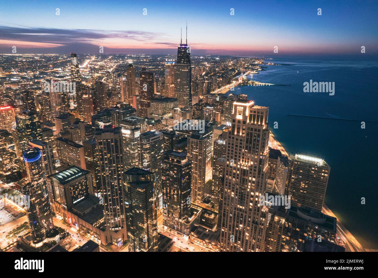 Une vue aérienne du paysage urbain illuminé de Chicago au coucher du soleil surplombant le lac Michigan Banque D'Images