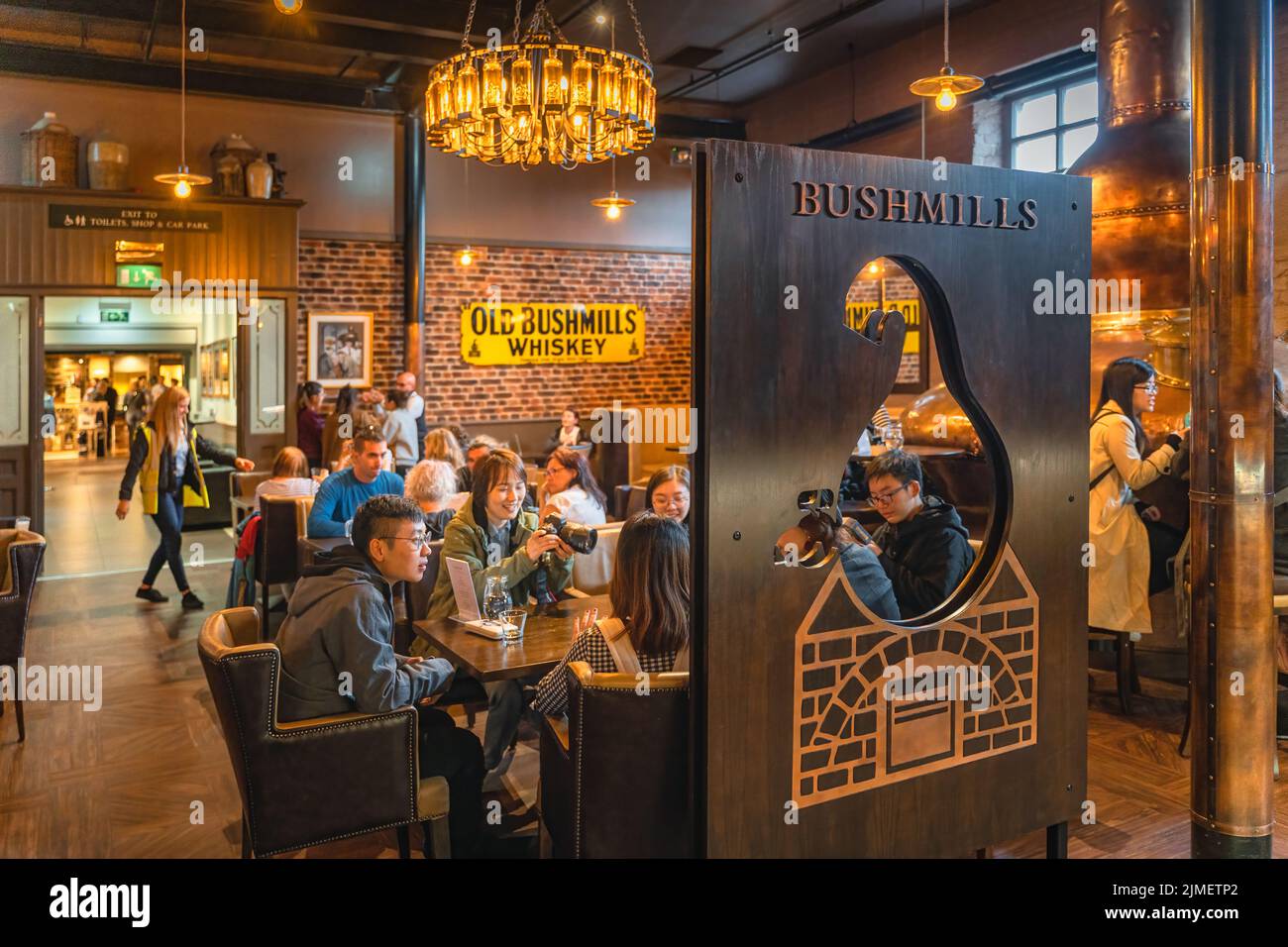 Touristes visitant la distillerie Old Bushmills et goûtant le whisky irlandais dans un bar Banque D'Images