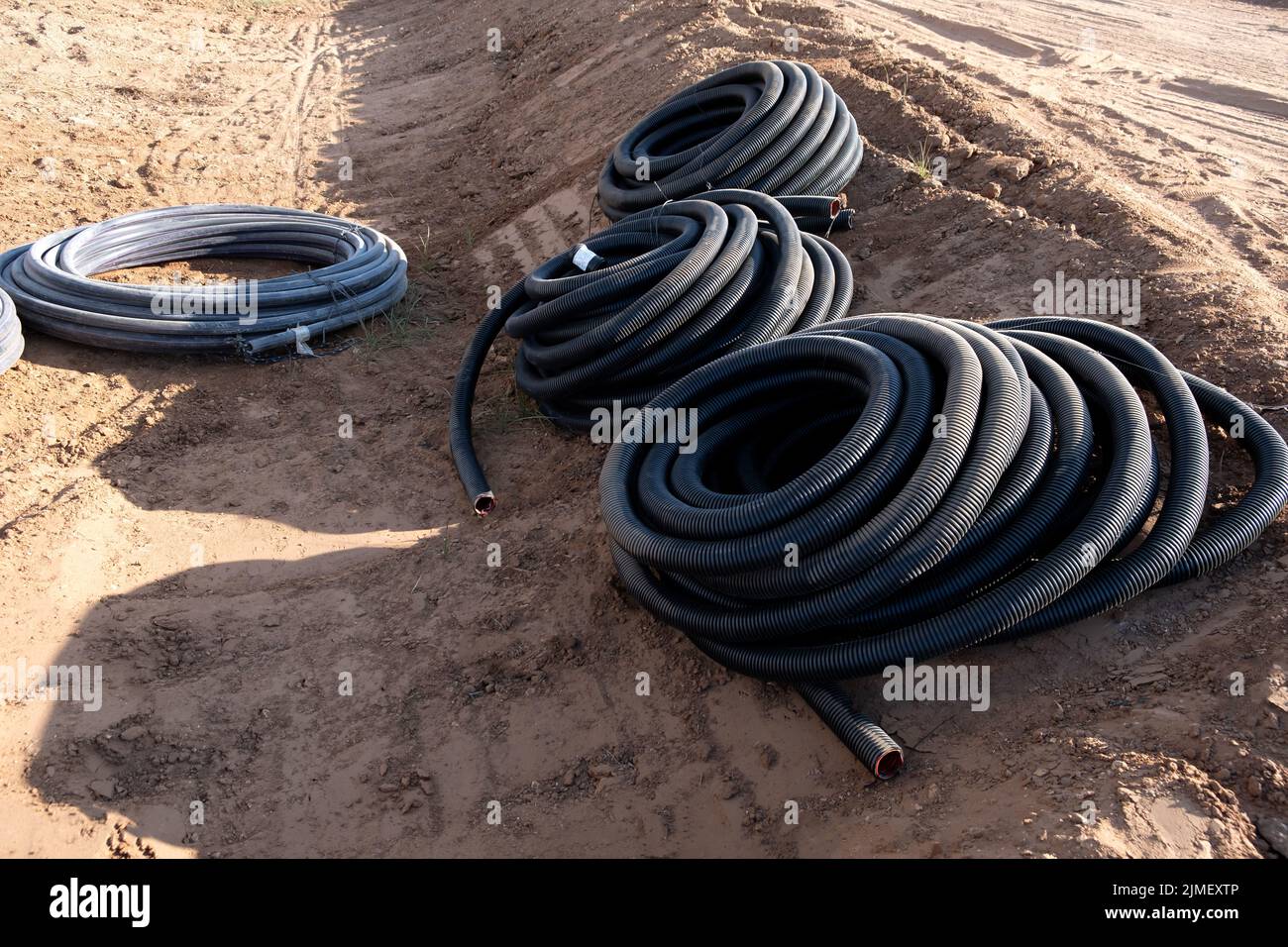 Installations de développement de communications, grande bobine de PVC tuyau noir tube plastique. Tuyaux sur le chantier de construction protéger les câbles dans l'électricité Banque D'Images