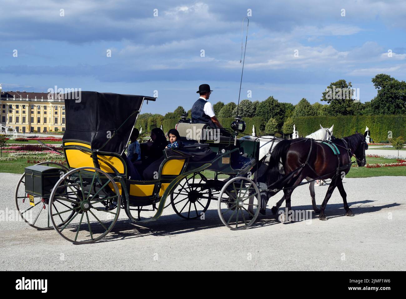 Vienne, Autriche - 01 août 2022 : touristes non identifiés dans une calèche appelée Fiaker et palais de Schönbrunn du 18th siècle - ancien Banque D'Images