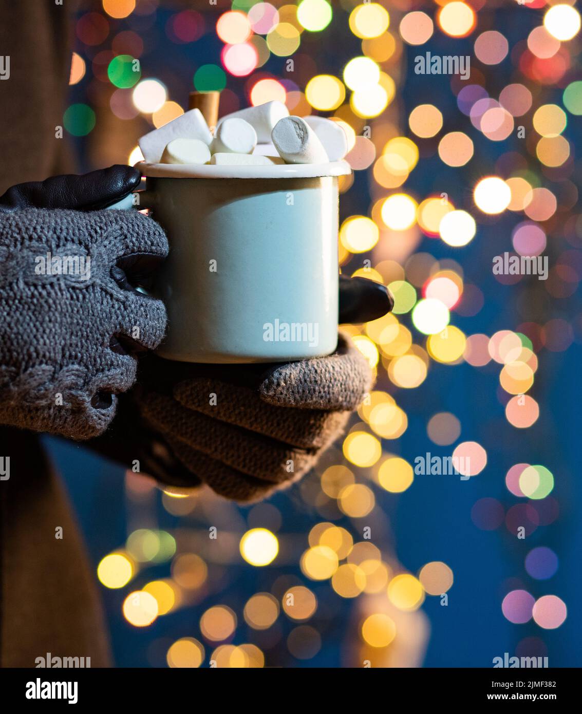 Femme tenant une tasse avec du vin chaud ou du chocolat chaud au marché de noël Banque D'Images