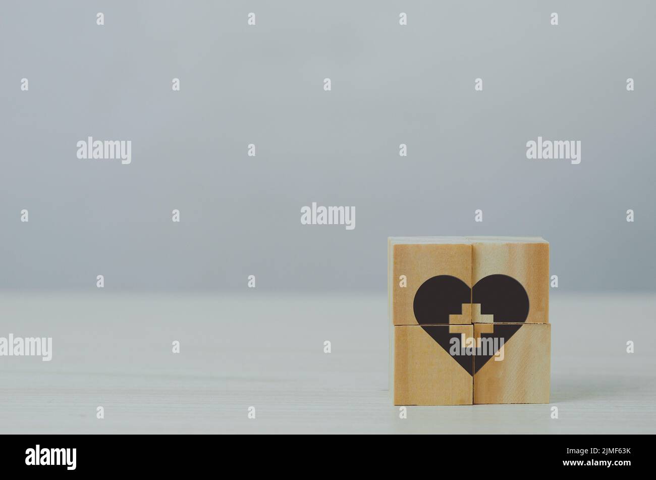 Cube en bois avec icône d'assurance maladie sur fond de table. Banque D'Images