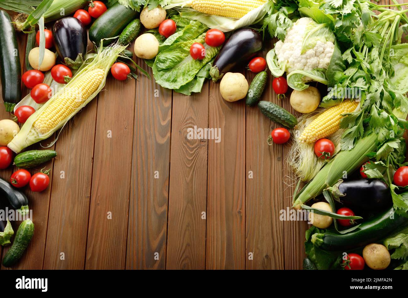 Légumes frais biologiques ingrédients alimentaires sur table de cuisine en bois, arrière-plan. L'espace pour le texte. Banque D'Images