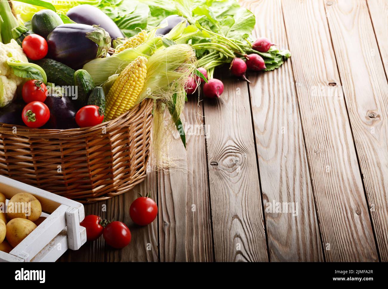 Panier de légumes bio ingrédients alimentaires et caisse de pommes sur fond de bois Banque D'Images