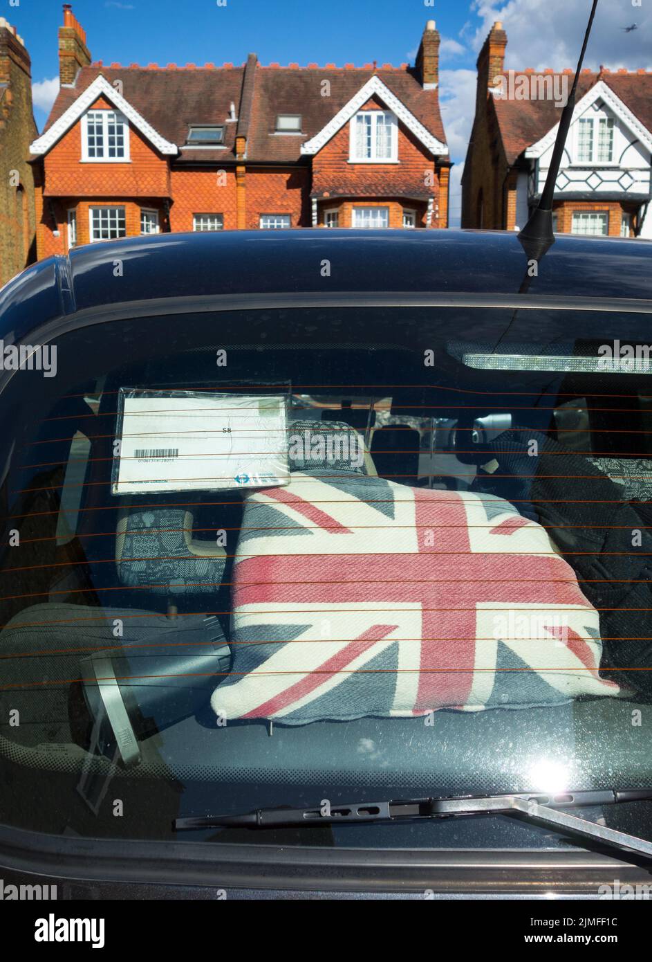 Gros plan d'un coussin Union Jack dans la lunette arrière d'une cabine de taxi noire de Londres Banque D'Images