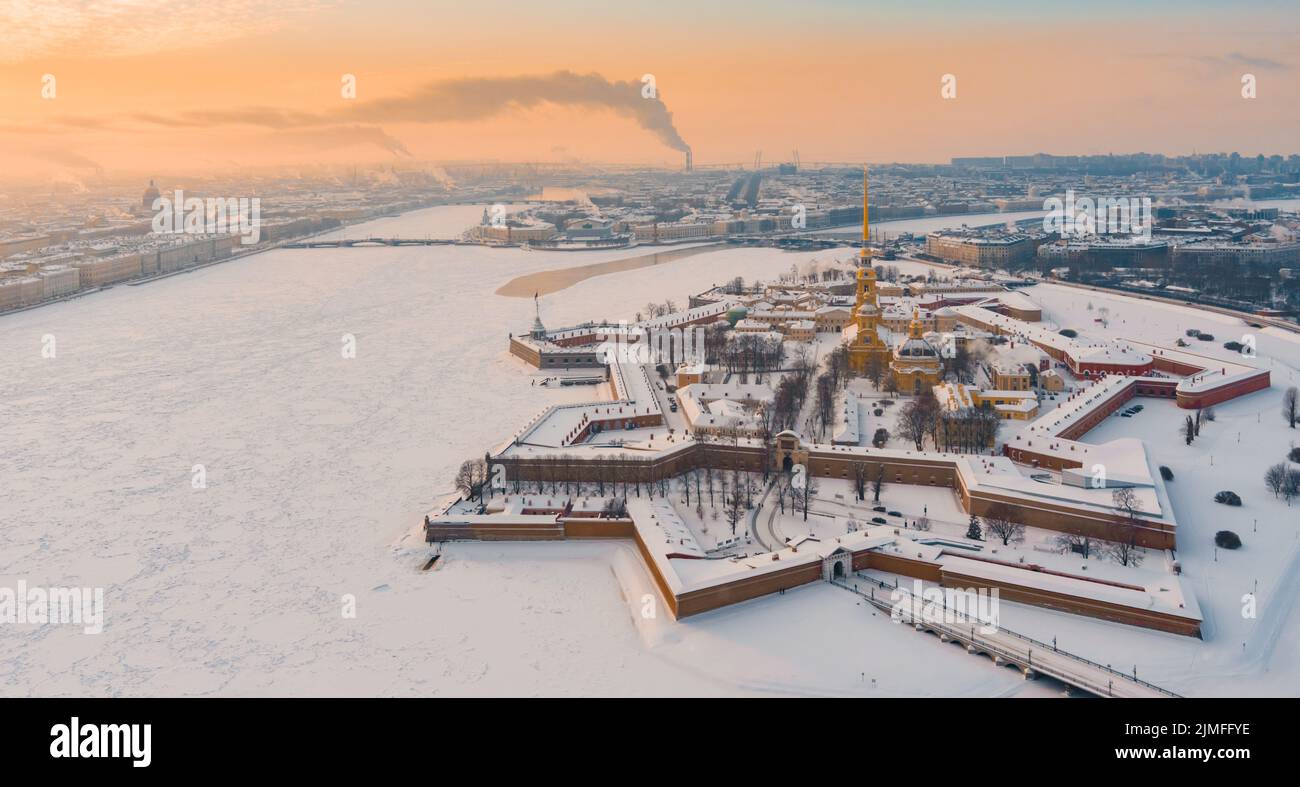 Drone point de vue de l'hiver Saint-Pétersbourg au coucher du soleil, rivière Neva gelée, vapeur au-dessus de la ville, forteresse Pierre et Paul, circulation automobile Banque D'Images