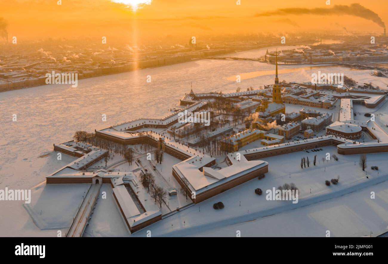Drone point de vue de l'hiver Saint-Pétersbourg au coucher du soleil, rivière Neva gelée, vapeur au-dessus de la ville, forteresse Pierre et Paul, circulation automobile Banque D'Images