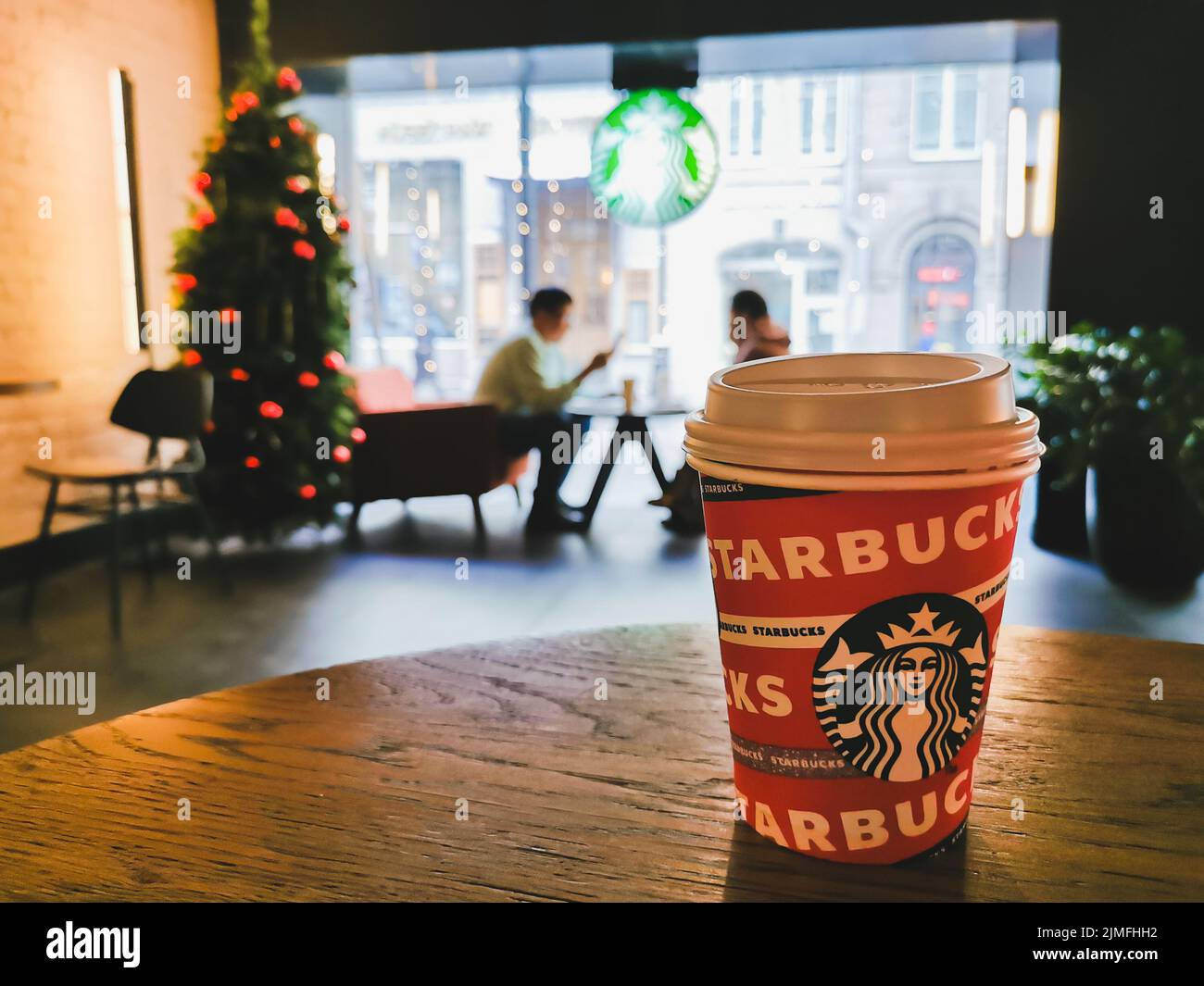 Une tasse de papier de café Starbucks sur une table dans un café. Banque D'Images