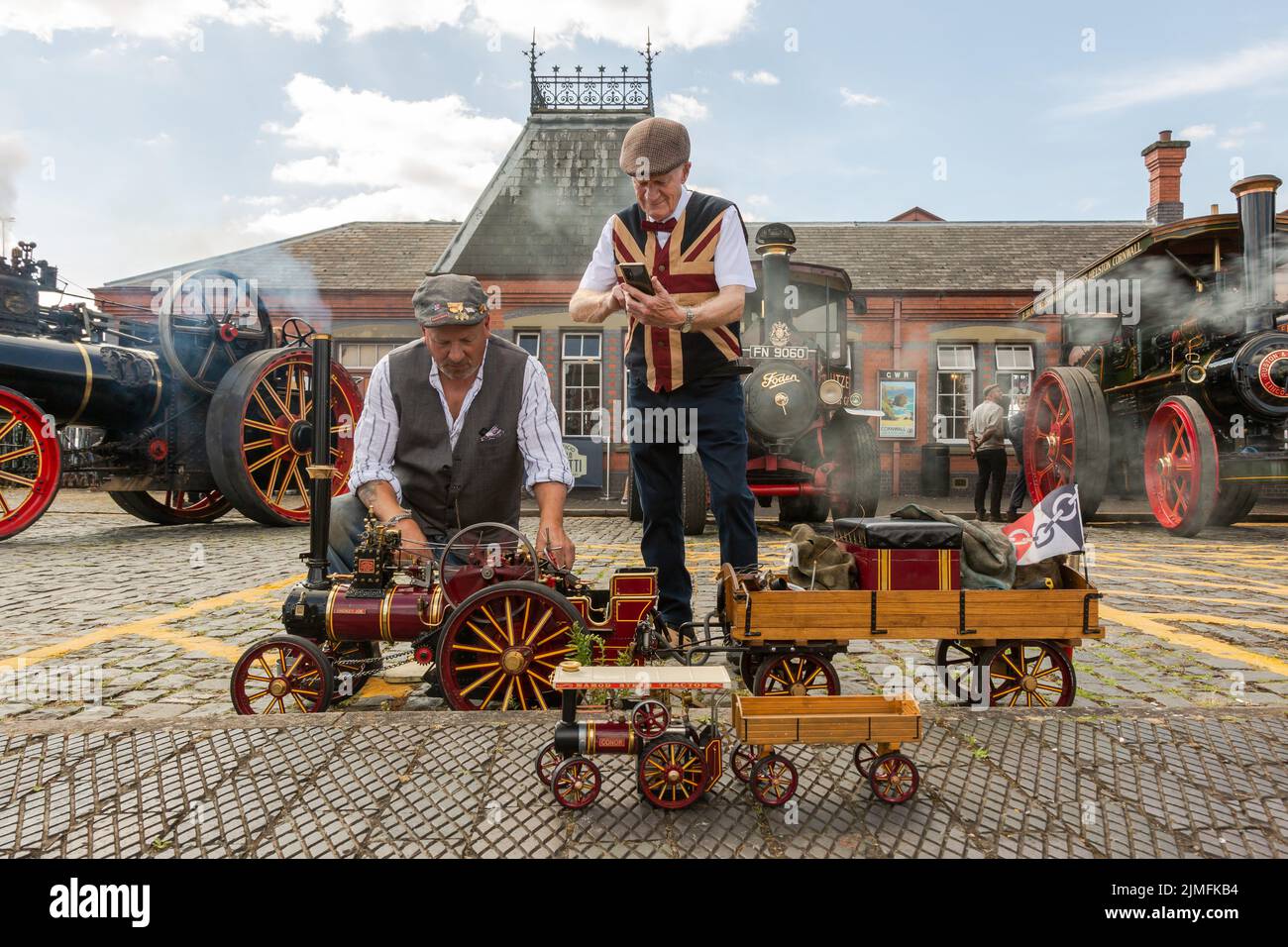 Kidderminster, Worcs, Royaume-Uni. 6th août 2022. Michael Pryce, passionné de vapeur, montre sa fierté et sa joie grâce à son moteur de traction à vapeur miniature à l'échelle 1:3, « Mokey Joe », en compagnie de Jim Parker, à l'occasion de l'Extravaganza de transport d'époque du Severn Valley Railway, à Kidderminster, dans le Worcestershire. L'événement annuel comprend des véhicules automobiles d'époque ainsi que des moteurs à vapeur. Crédit : Peter Lophan/Alay Live News Banque D'Images