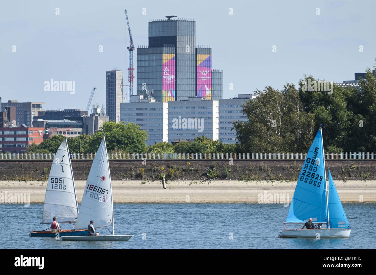 Réservoir Edgbaston, Birmingham, Angleterre, 6 août 2022. - Les marins de loisirs ont pris dans les eaux basses du réservoir Edgbaston au soleil torant samedi après-midi. Les bateaux ont passé la toile de fond du centre-ville avec la Tour BT et 103 Colmore Row avec la signalisation des Jeux du Commonwealth. Le niveau d'eau est très bas en raison de plusieurs semaines de temps sec. Photo par crédit : Michael Scott/Alay Live News Banque D'Images