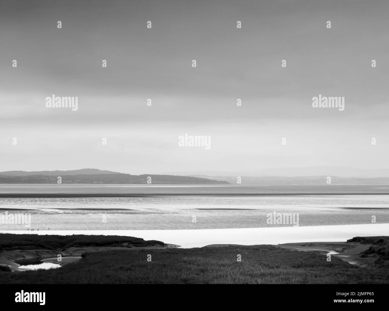 Vue atmosphérique monochrome de la côte de grange sur les sables de cumbria avec une zone humide recouverte d'herbe au premier plan et le no Banque D'Images