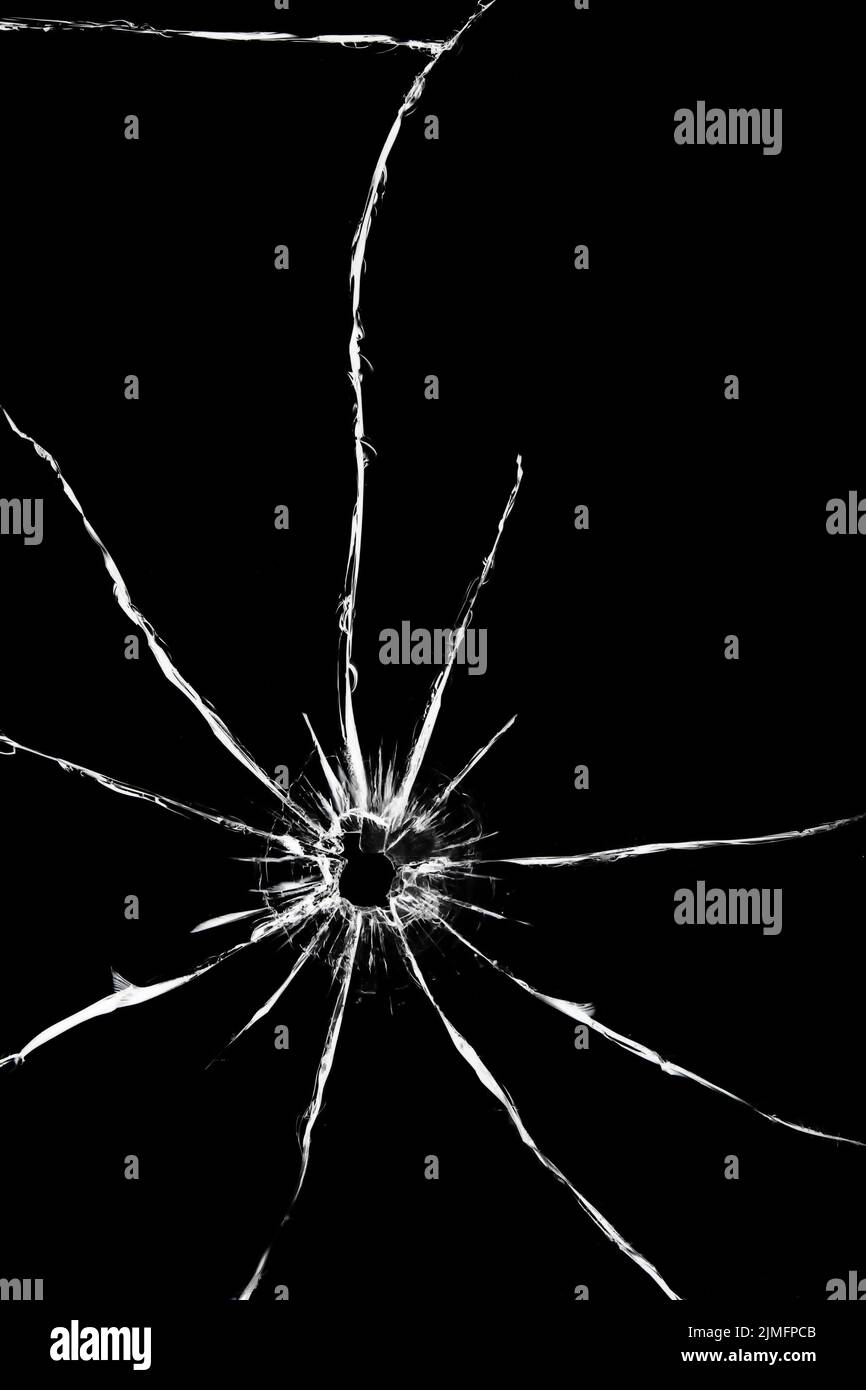 Trou d'un tir avec une arme dans le verre. Fissures à l'arrière de la voiture. Texture sur fond noir, l'effet de cassé Banque D'Images