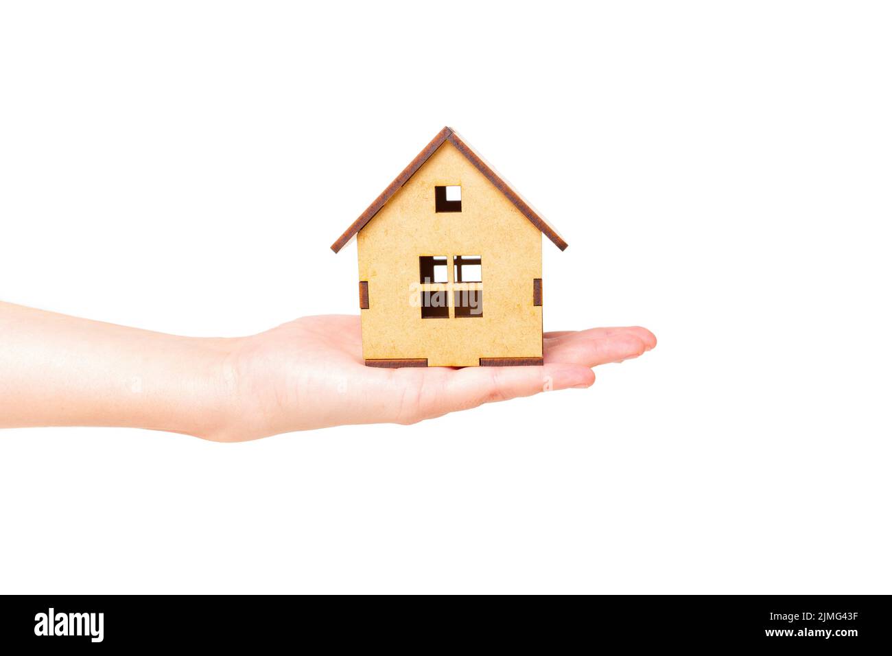 Modèle de maison en bois miniature isolé à la main sur fond blanc. Concept d'offre immobilière. Banque D'Images