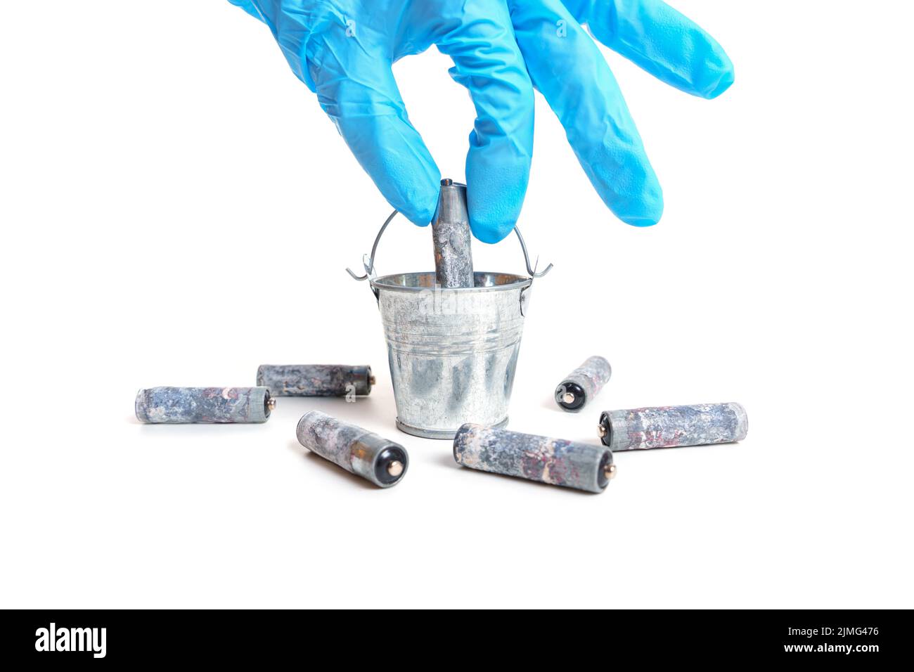 Main gantée mettant une batterie usagée dans un godet miniature en acier isolé sur fond blanc. Banque D'Images