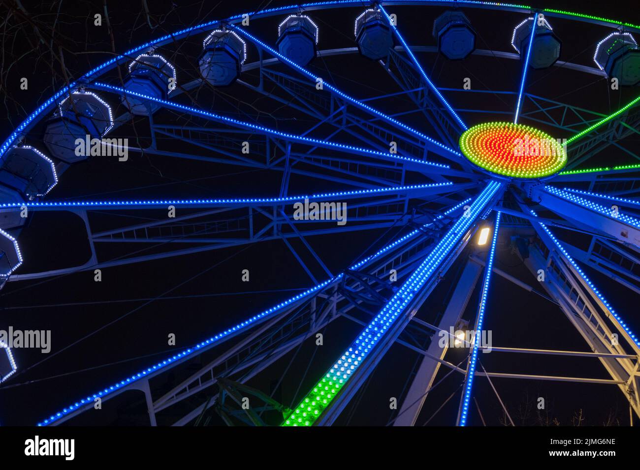 Grande roue magnifiquement éclairée la nuit à Leeds par l'hôtel de ville. Banque D'Images