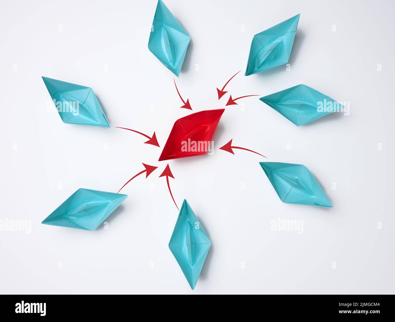 Des bateaux en papier bleu autour du rouge au centre. Le concept de s'unir autour d'un leader fort. Intimidation et conflit dans la t Banque D'Images