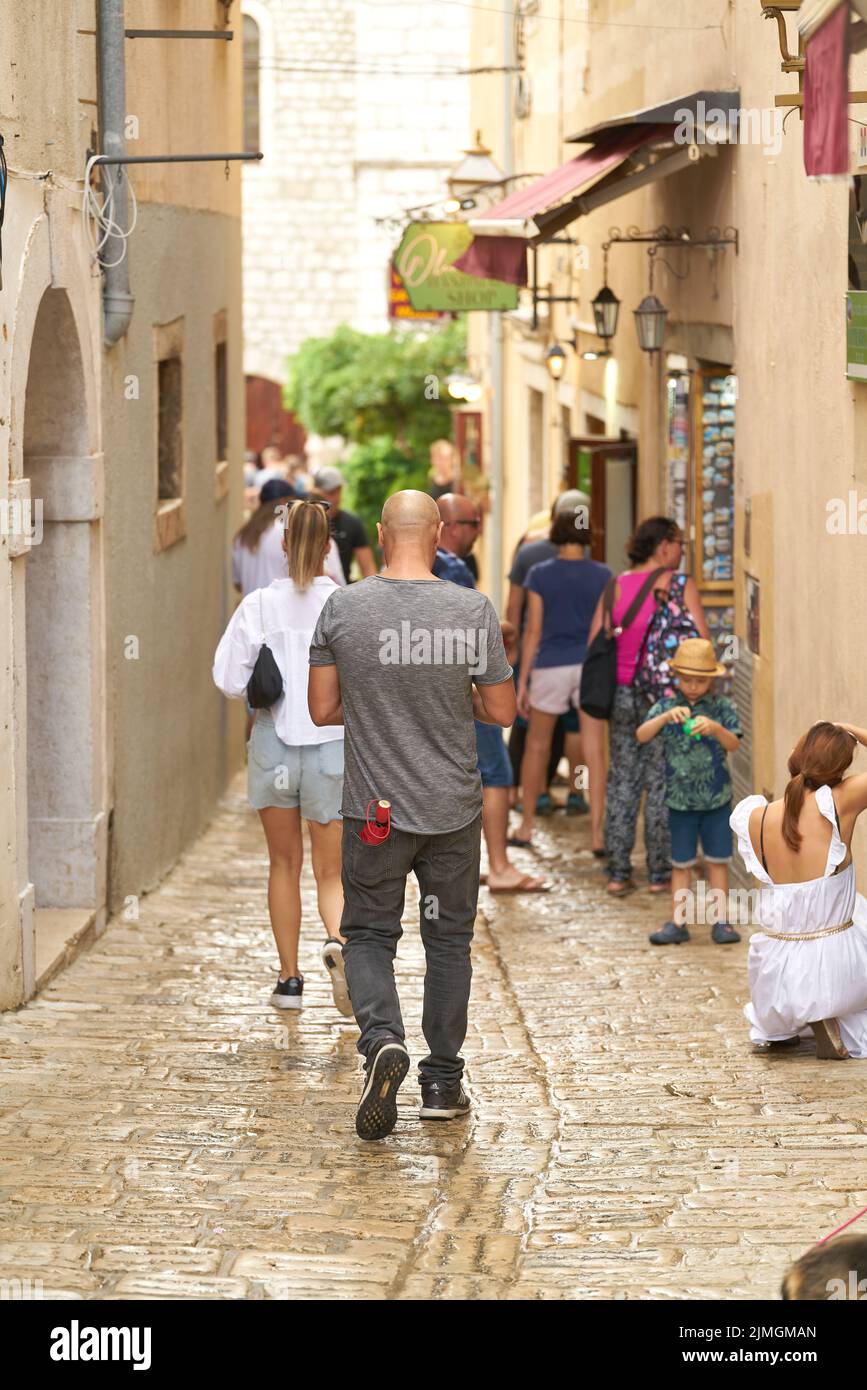 Touristes dans une allée avec des magasins dans la vieille ville de Krk en Croatie Banque D'Images