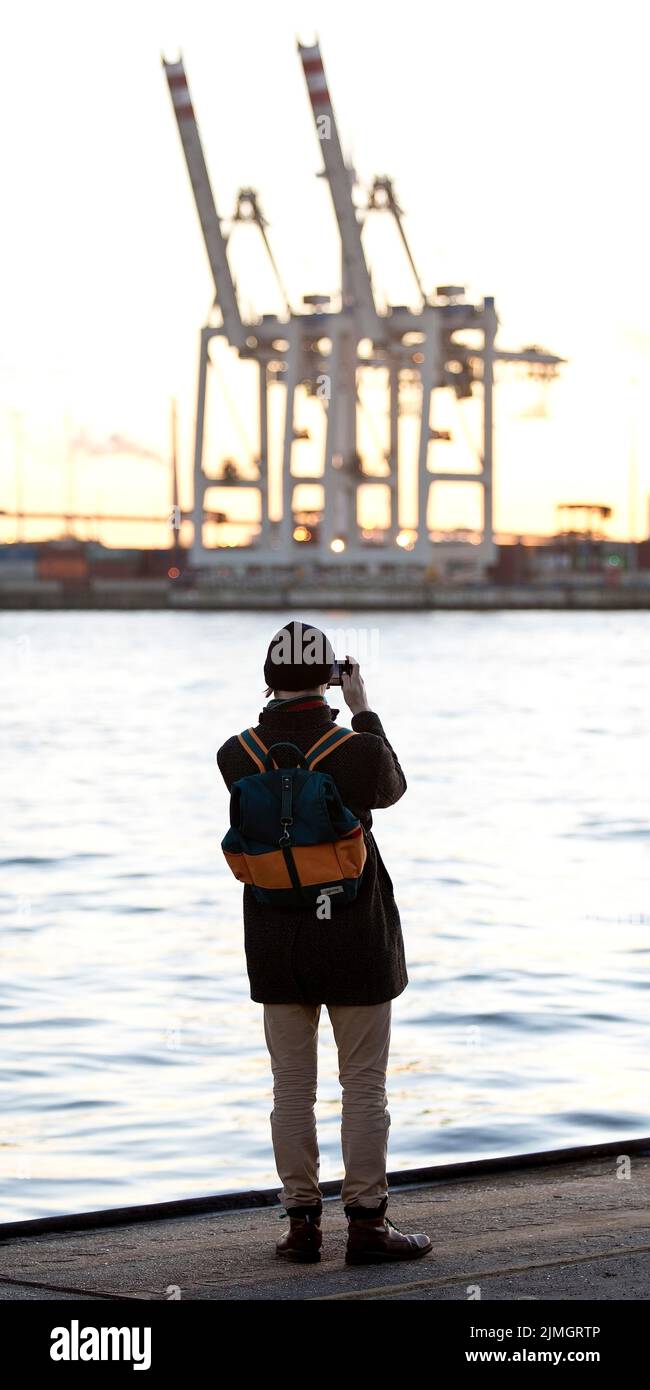 Une personne photographie des grues de chargement sur l'Elbe Nord à Altona, Port de Hambourg, Allemagne, Europe Banque D'Images