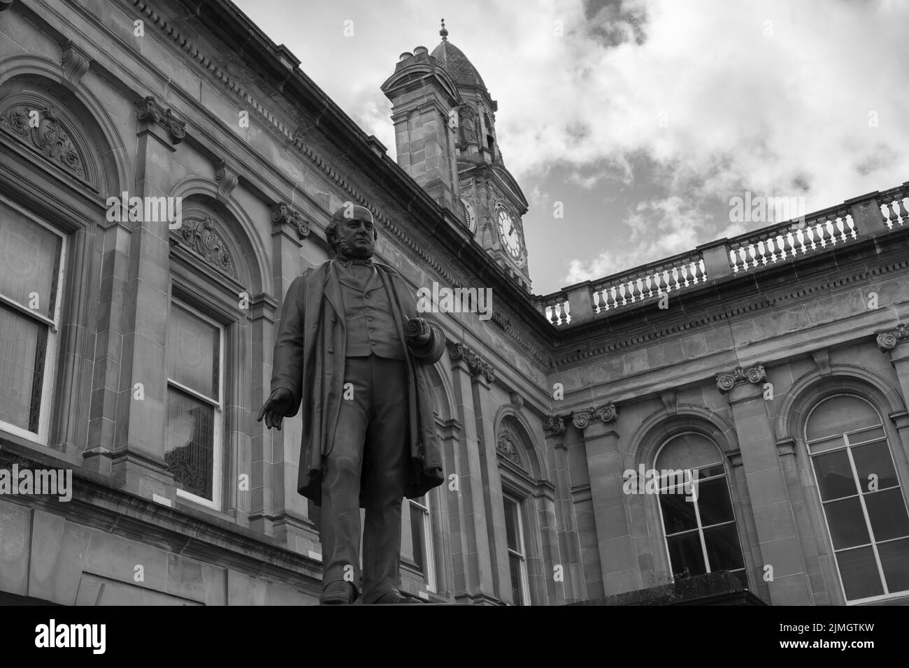 Photo en bas angle de la statue de George Aitken Clark à côté de l'hôtel de ville de Paisley en niveaux de gris Banque D'Images