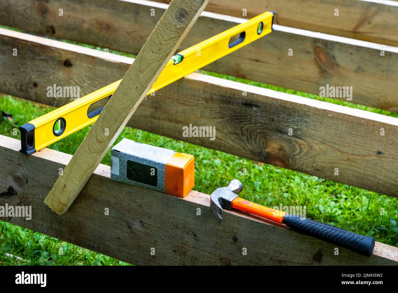 Un marteau de construction, une boîte de clous et un niveau de construction Banque D'Images