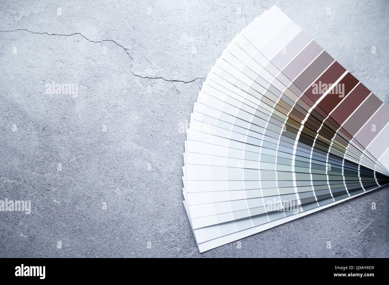 Échantillons de peinture nuance de couleurs pour le design intérieur. Fond gris en béton fissuré, couleurs terre. Banque D'Images