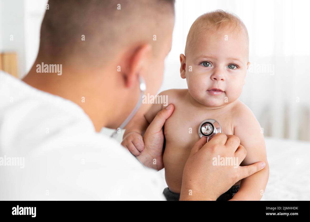 Vue arrière médecin écoutant le petit bébé avec un stéthoscope Banque D'Images