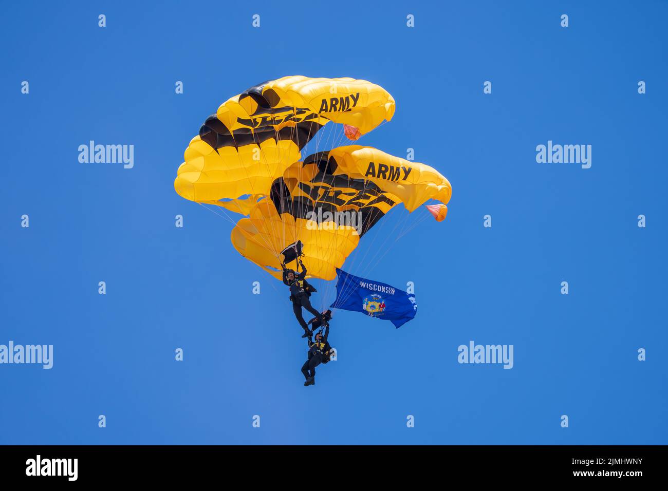 Sgt. 1st classe Dominic Perry et Sgt. 1st classe Rafael Torres de l'équipe de parachutisme de l'armée américaine flottent le drapeau de l'État du Wisconsin au-dessus de Madison, Wisconsin, le 5 août 2022 avant d'atterrir dans l'arène des CrossFit Games. (É.-U. Photo de l'armée par Megan Hackett) Banque D'Images