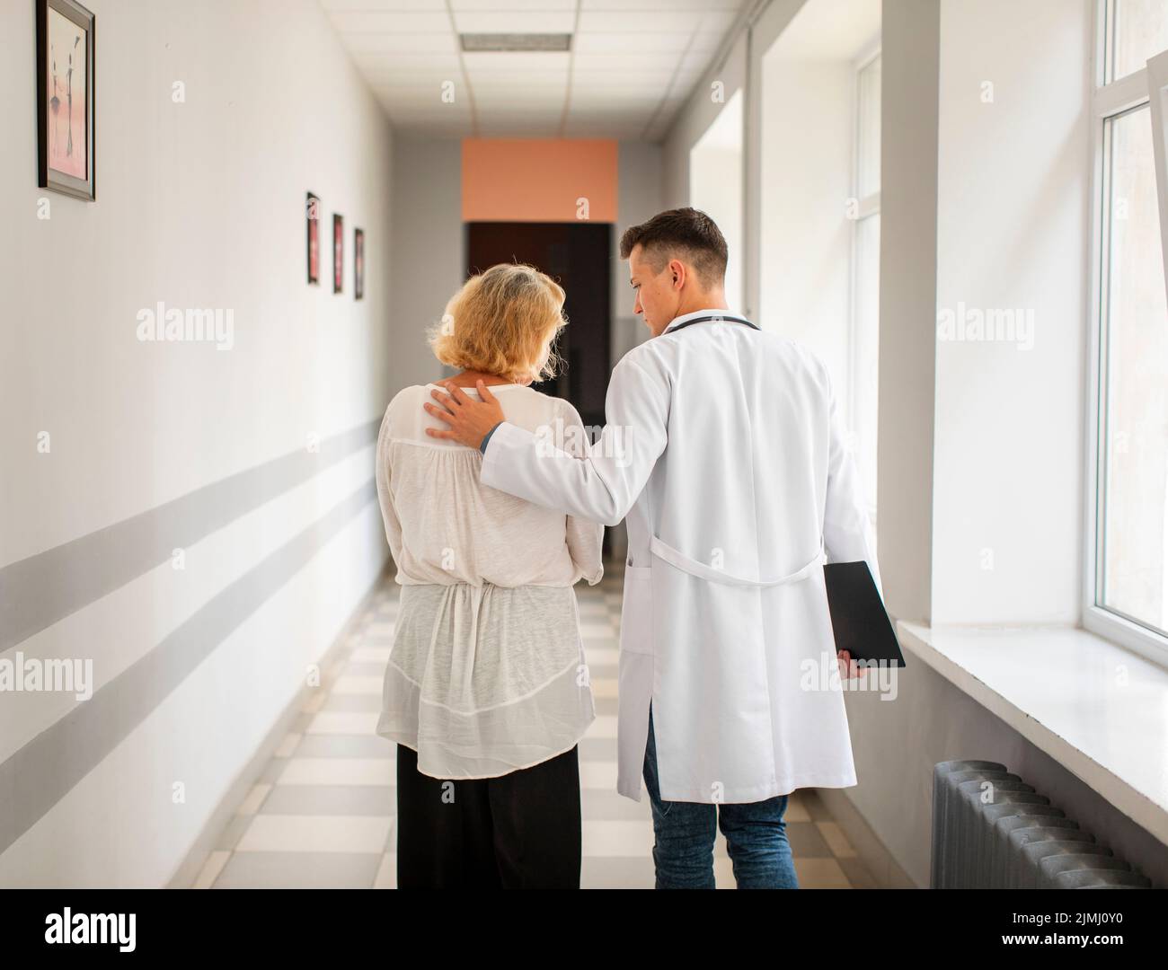 Vue arrière médecin femme âgée marchant Banque D'Images
