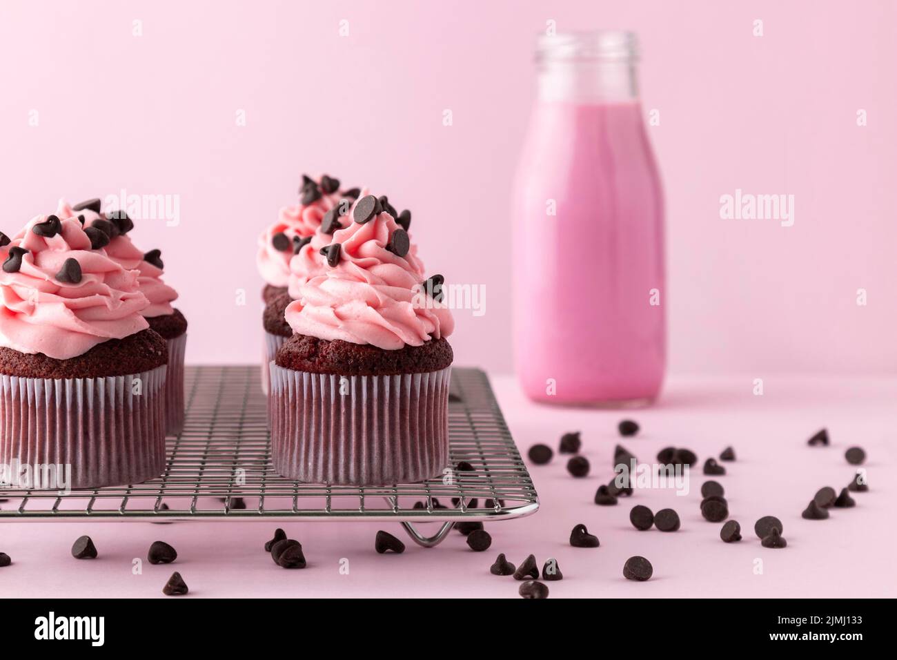Petits gâteaux avec boisson rose verglaçante Banque D'Images