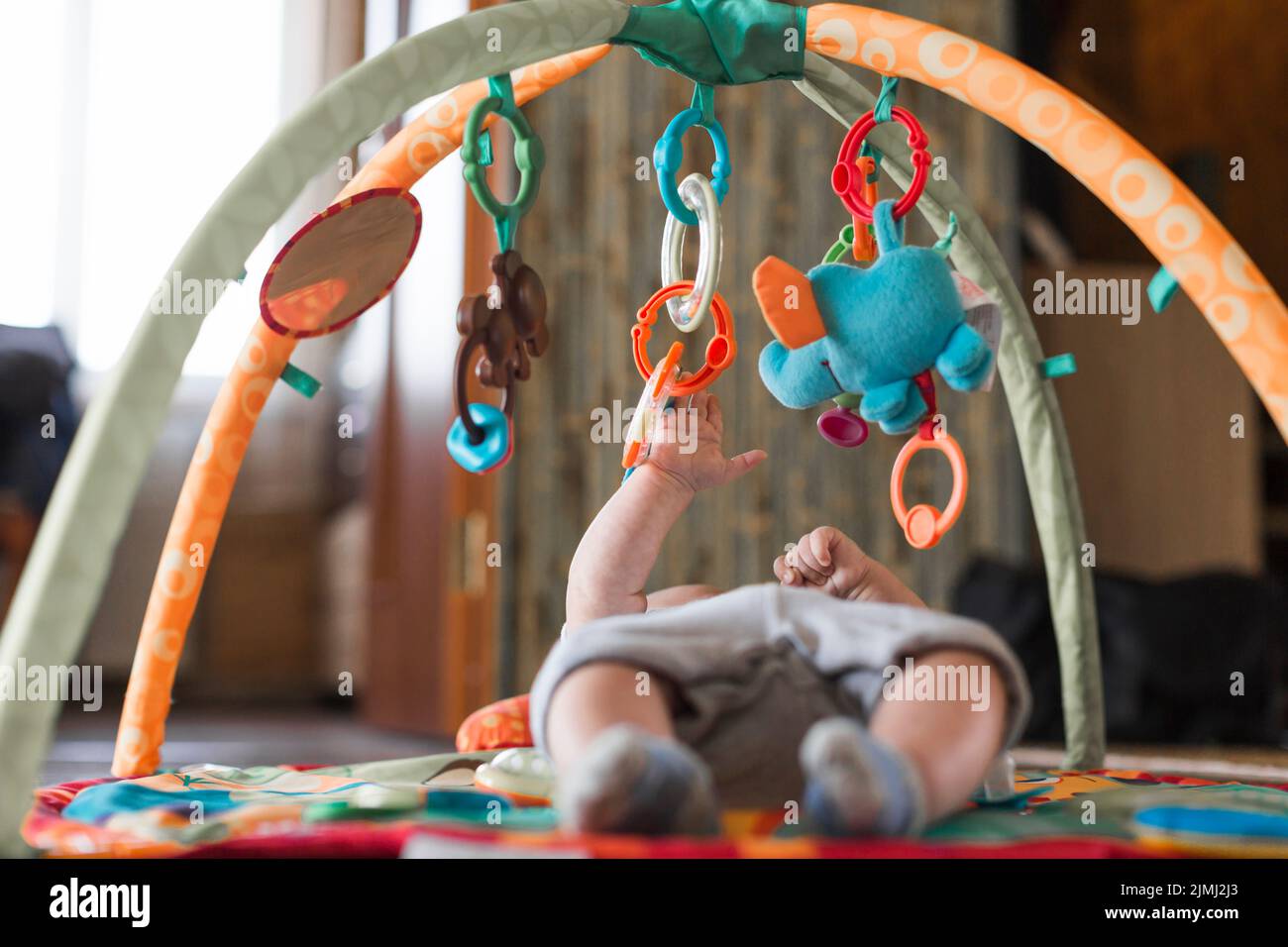 Tapis de développement couché pour bébé avec jouets éducatifs mobiles Banque D'Images