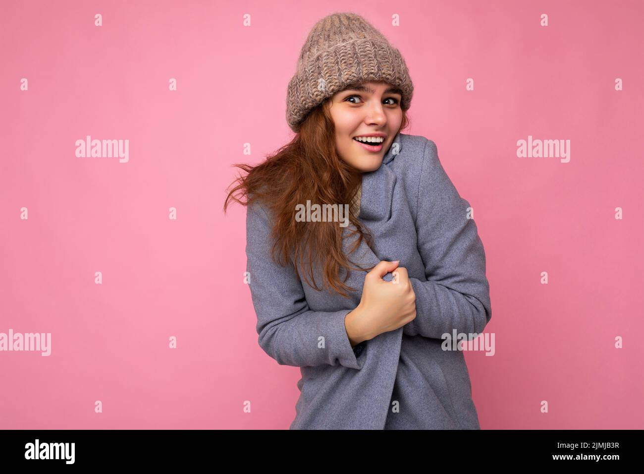 Belle positive heureuse jeune femme brune isolée sur fond coloré mur portant des vêtements décontractés stylés sensation de péché Banque D'Images