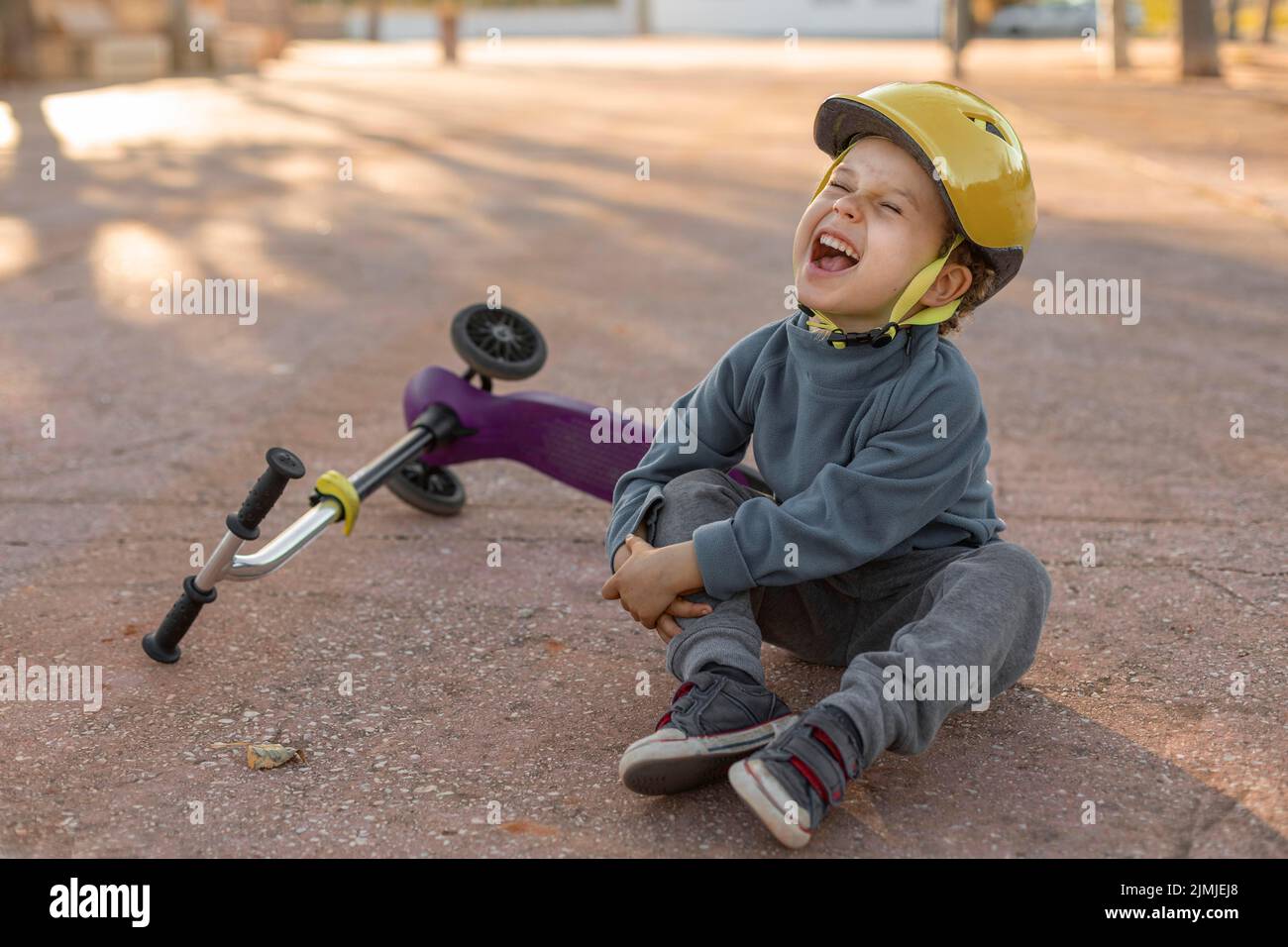 Petit garçon à l'extérieur blessé par le scooter Feel Banque D'Images