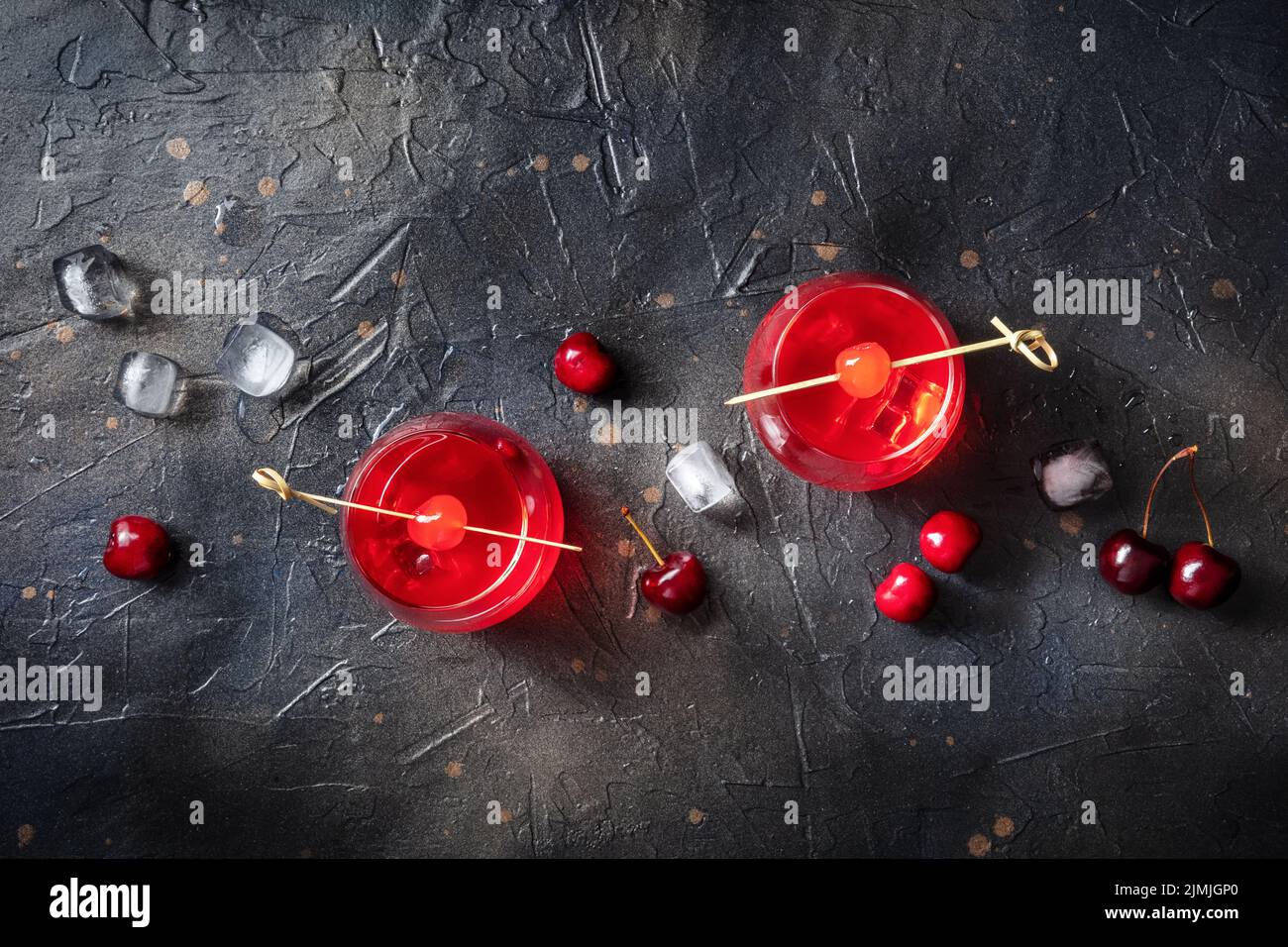 Cocktails avec cerises. Boissons alcoolisées sur fond noir, avec de la glace Banque D'Images