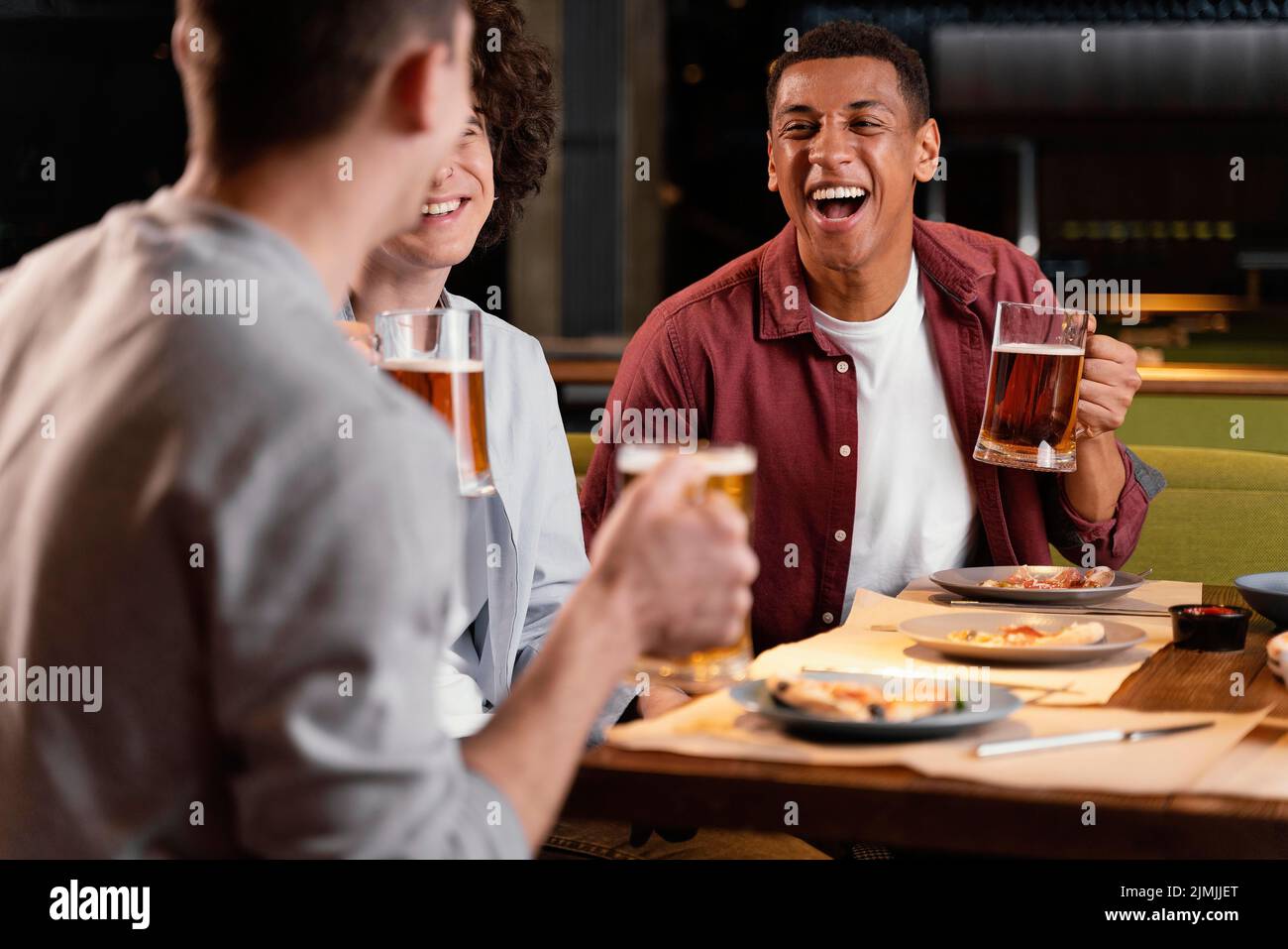 Gros plan sur des hommes heureux avec des tasses à bière Banque D'Images