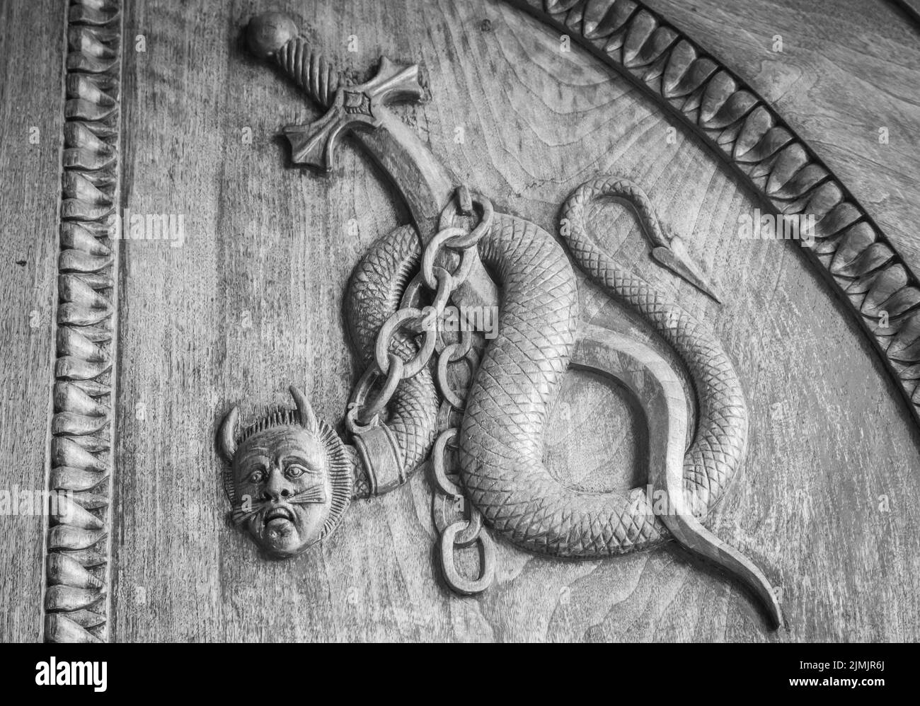 Symbole serpent de diable. Créature magique fantaisie sur une vieille porte, abbaye du 12th siècle en Italie. Banque D'Images
