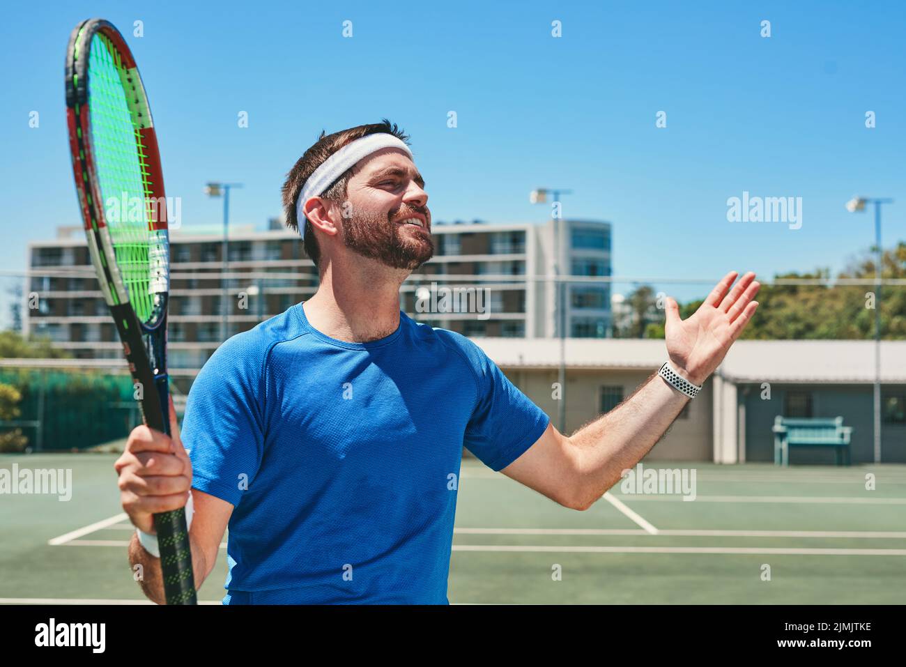 Oh allez, un beau jeune homme se sentant frustré en jouant au tennis pendant la journée. Banque D'Images