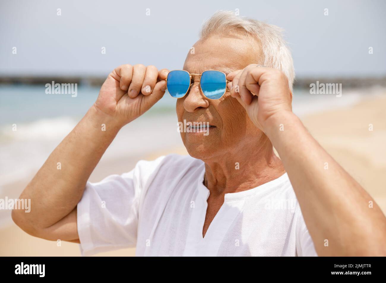 Joyeux homme de longue âge qui marche sur la plage Banque D'Images