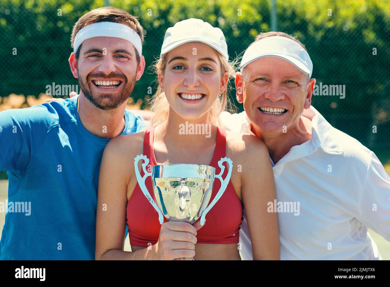 Image de la victoire est nécessaire. Portrait court d'un groupe de sportifs debout ensemble et tenant un trophée après avoir remporté un match de tennis. Banque D'Images