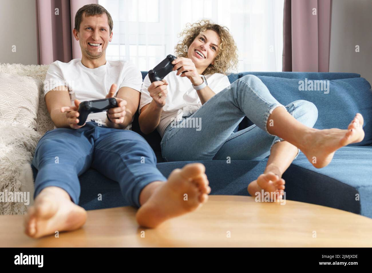 Jeune couple heureux jouant à la console de jeux vidéo Banque D'Images