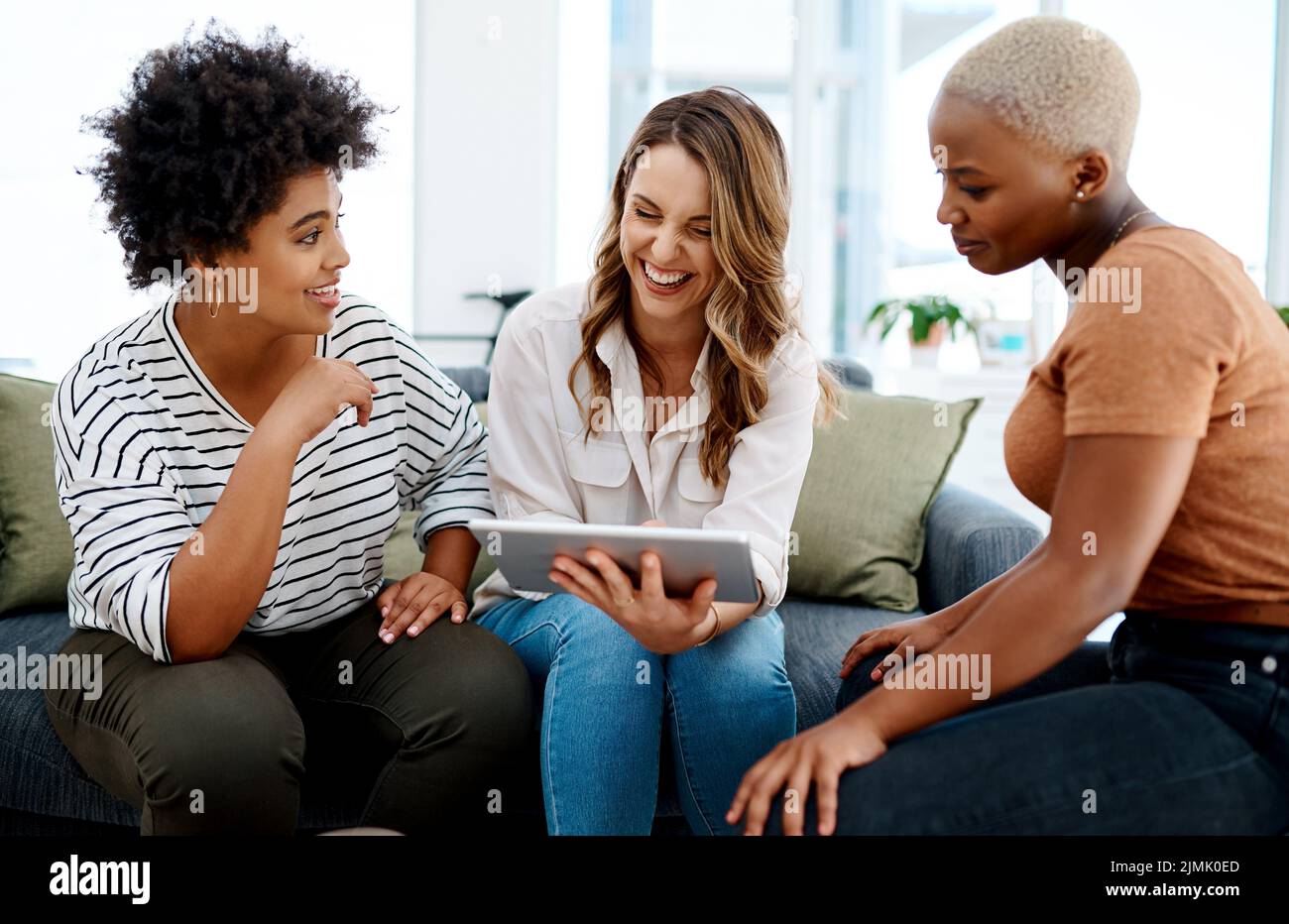 Il s'agit de rester innovant et pertinent dans l'industrie. Un groupe de femmes d'affaires travaillant ensemble sur une tablette numérique dans un bureau. Banque D'Images