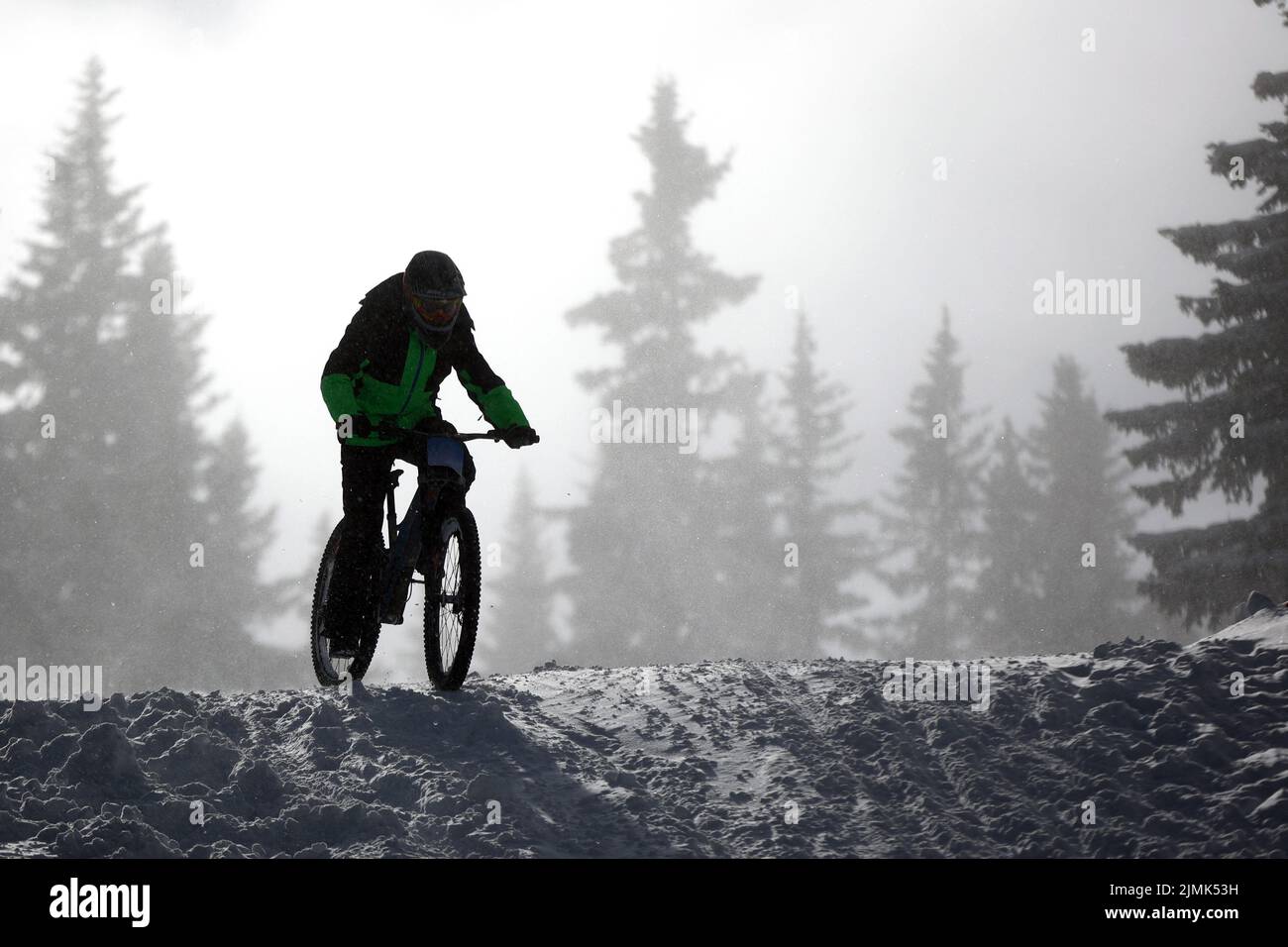 Cycliste extrême de vélo de montagne dans la neige Banque D'Images