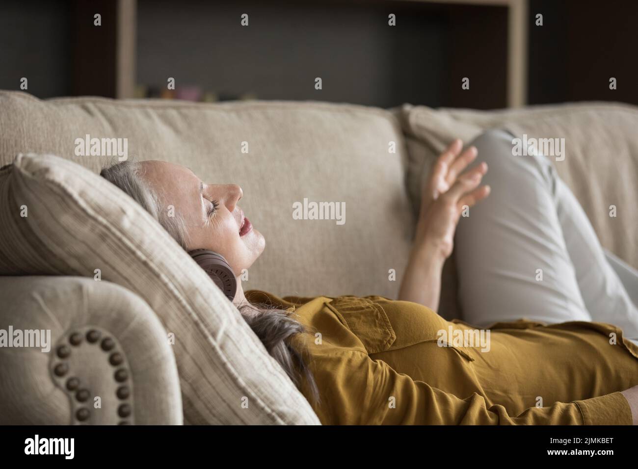 Heureuse femme adulte excitée portant un casque moderne Banque D'Images