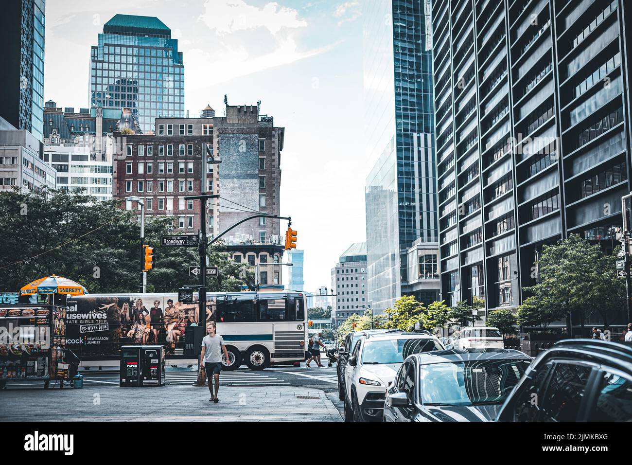 Vue sur un quartier financier actif de New York, près de Broadway, avec des voitures et des personnes à pied Banque D'Images